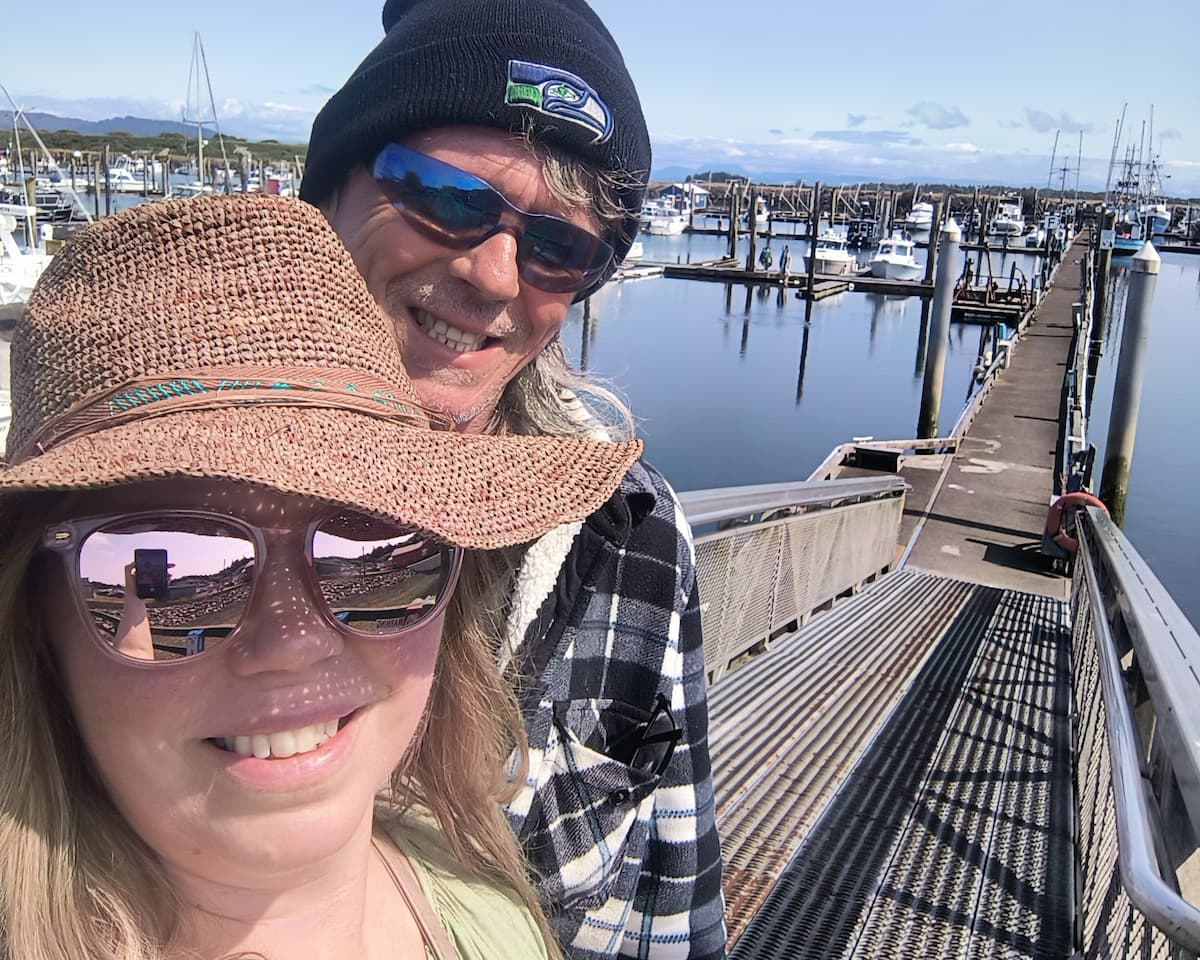Smiling hosts standing in front of a coastal home
